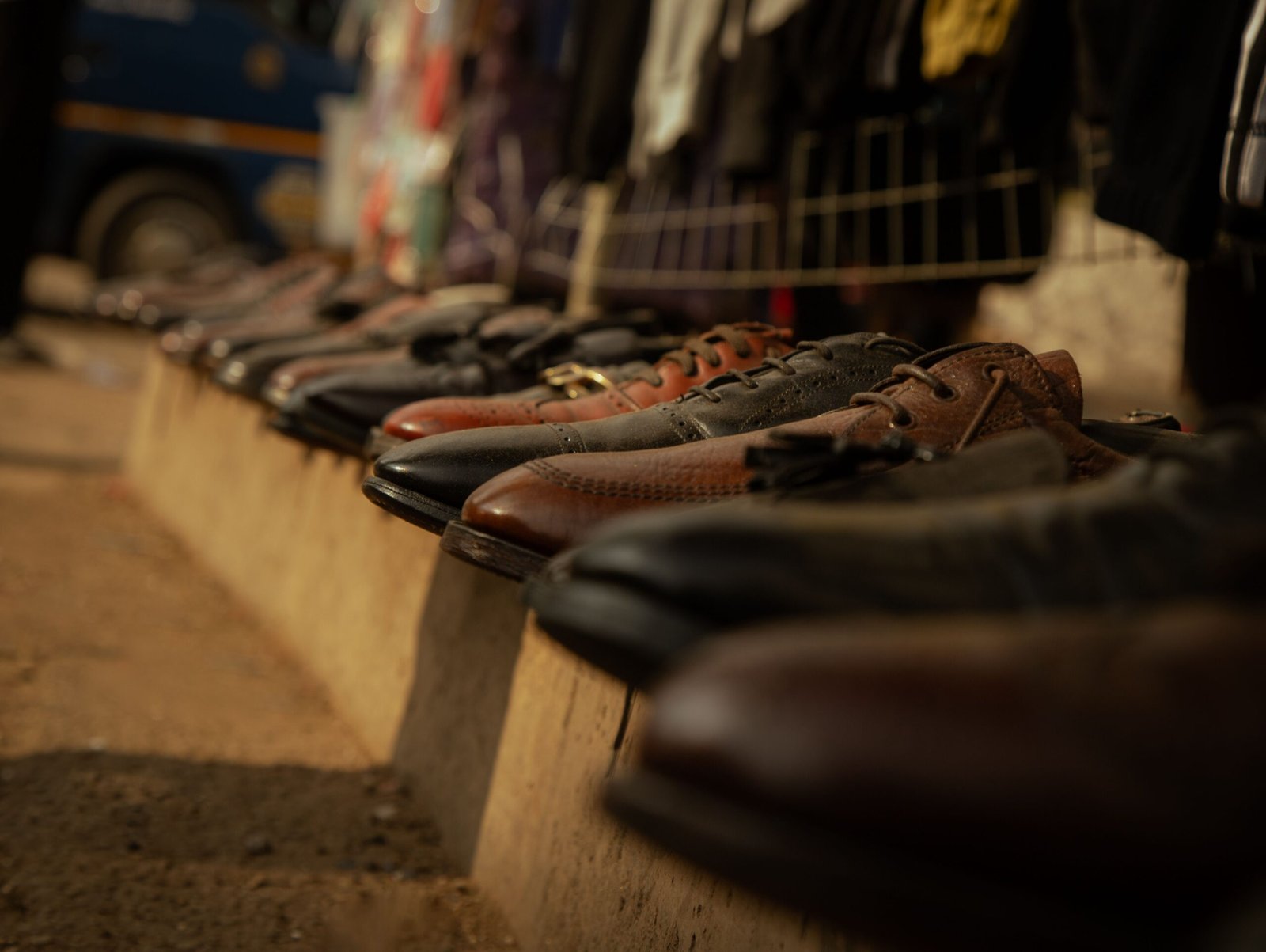 Close-up of brown leather shoes lined up at an outdoor market stall.